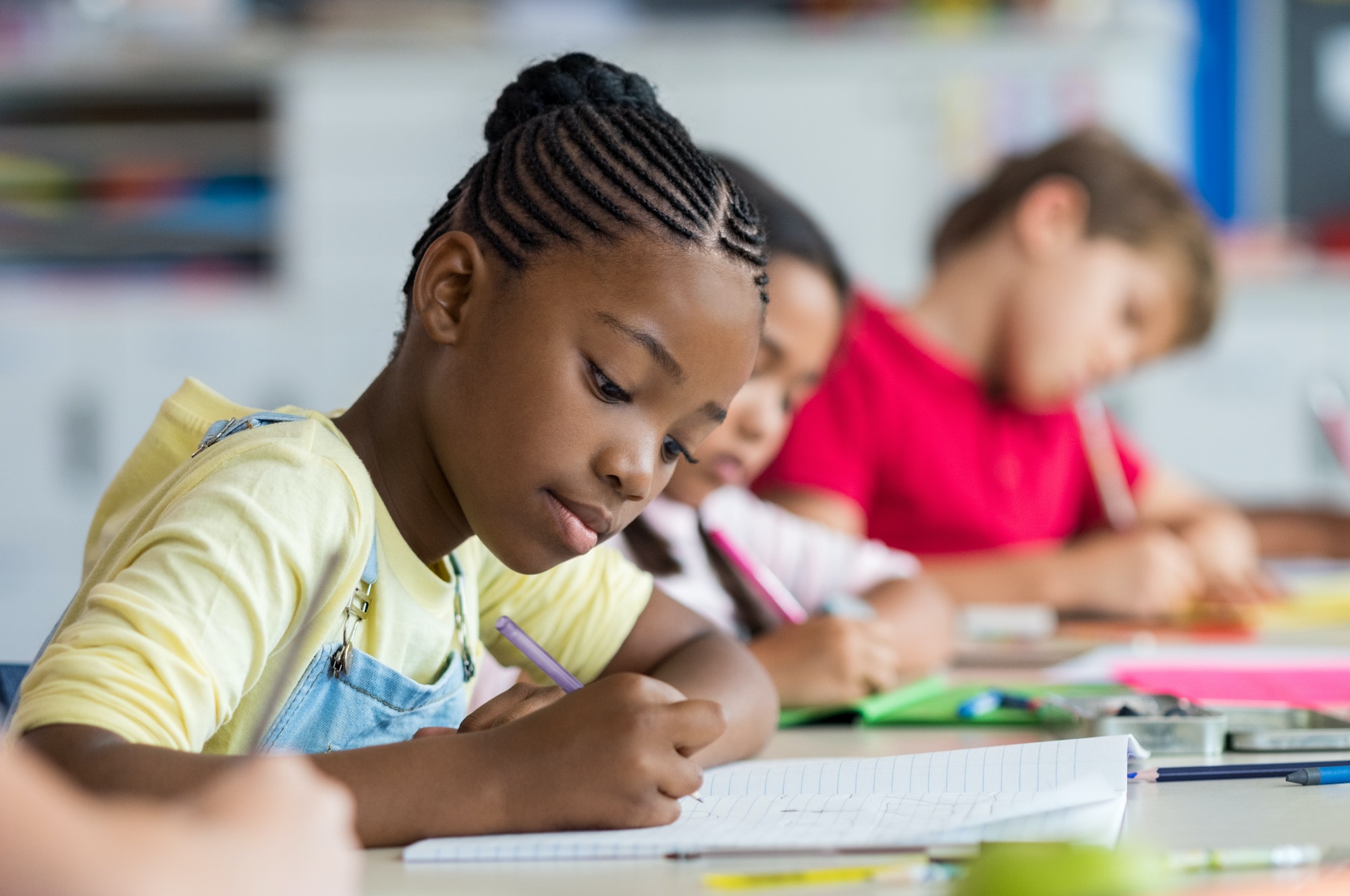 school girl writing in class 1